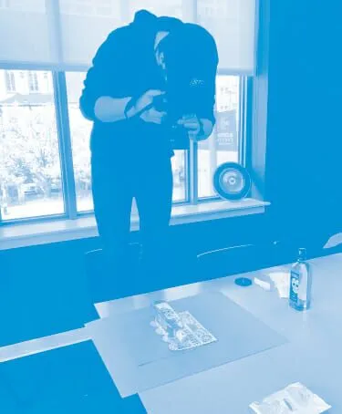 A man capturing an image of a table with his camera, showcasing its intricate design and arrangement.