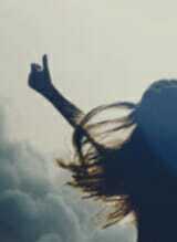 Woman celebrating with arms raised.