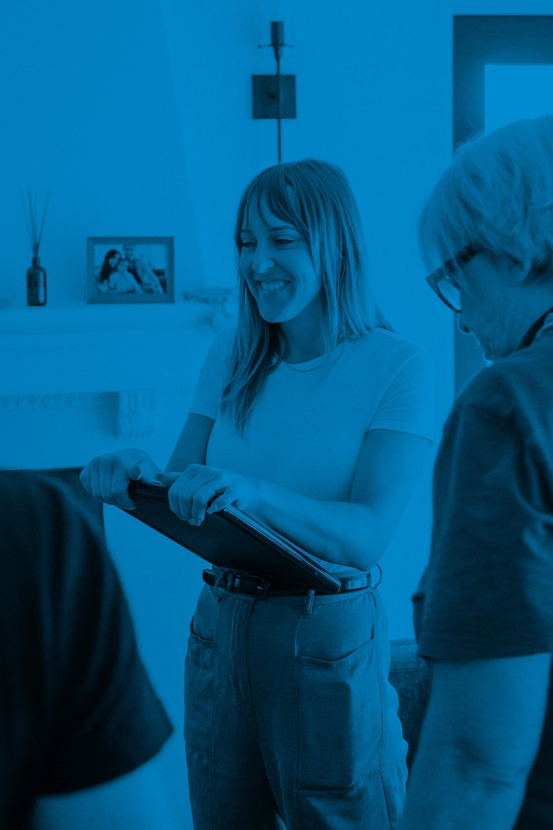 A woman engaging in conversation with a group of individuals in an office setting.