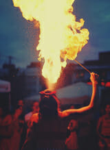 A woman holding a fire stick, ready to ignite flames.
