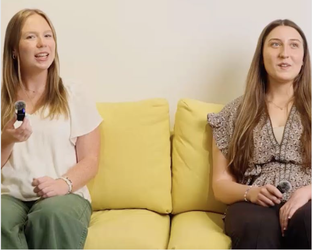 Leah and Camryn sit on a yellow couch holding microphones