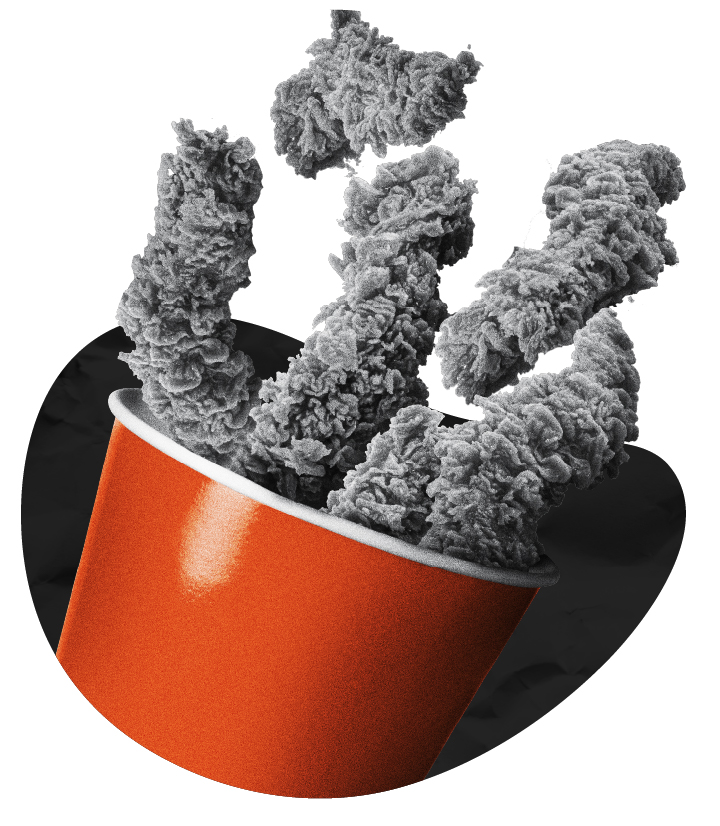 Fried chicken tenders spilling out of an orange fast-food cup