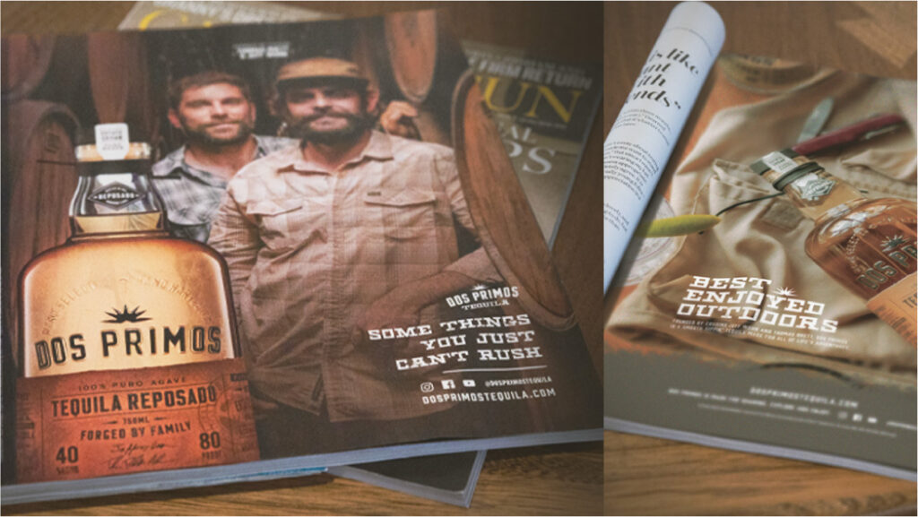 Dos Primos Tequila Reposado beside printed campaign pieces on a wooden table.