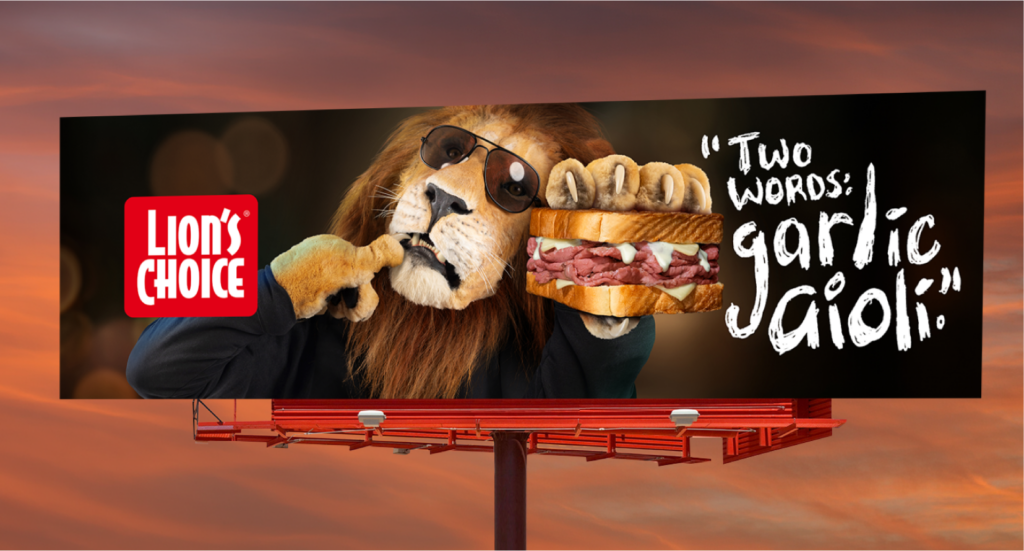 A Lion's Choice billboard at dusk: the lion eating a roast beef sandwich beside the words Two words: garlic aioli.